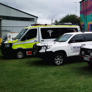 Ambulance, Comtel branded vehicle and police vehicle parked in front of Comtel offices